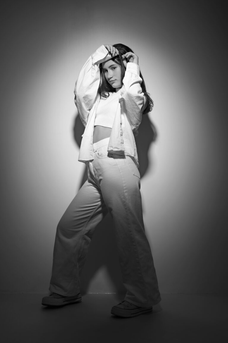 photo noire et blanc en studio , femme brun cheveux long habillé en blanc.